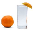 Navel Orange Hard Seltzer in a glass with an orange wedge and orange adjacent