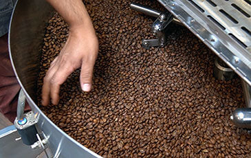 Image of a hand inside a coffee roaster