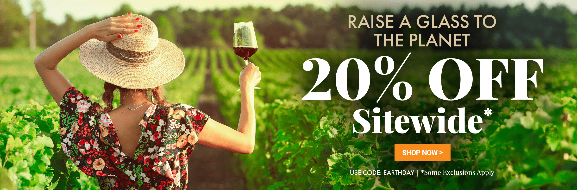 Woman in a vineyard holding a glass of wine with promotional text overlay Raise a Glass to the Planet 20% off Sitewide* Use Code: EARTHDAY *Some Exclusions Apply.