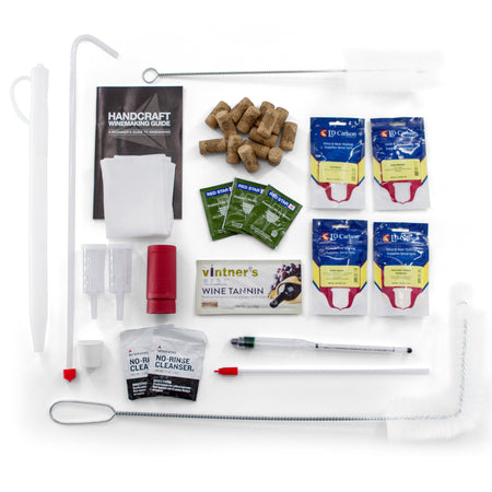 Top-down view of the Master Vintner Fresh Harvest 3-Gallon Fruit Winemaking Kit contents, including wine yeast packets, corks, sanitizer, wine tannin, airlocks, racking cane, tubing, hydrometer, and instructional guide — everything arranged neatly on a white background for beginner home winemakers.