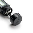 Close-up of the Milwaukee pH54 battery compartment with cap removed, showing the battery contacts and pull tab for easy battery replacement.