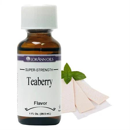 A bottle of Lorânn Oils Super-Strength Teaberry flavor essential oil, shown with a white cap, white label, amber glass bottle, and a small green teaberry leaf garnish on a white background.