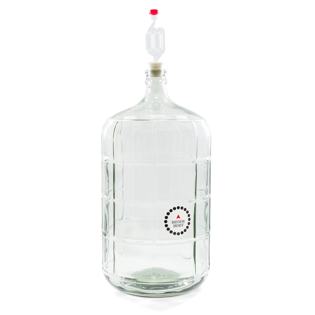 Glass carboy with an airlock and Northern Brewer temperature strip attached, used for secondary fermentation in home wine making.