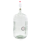 Glass carboy with an airlock and Northern Brewer temperature strip attached, used for secondary fermentation in home wine making.