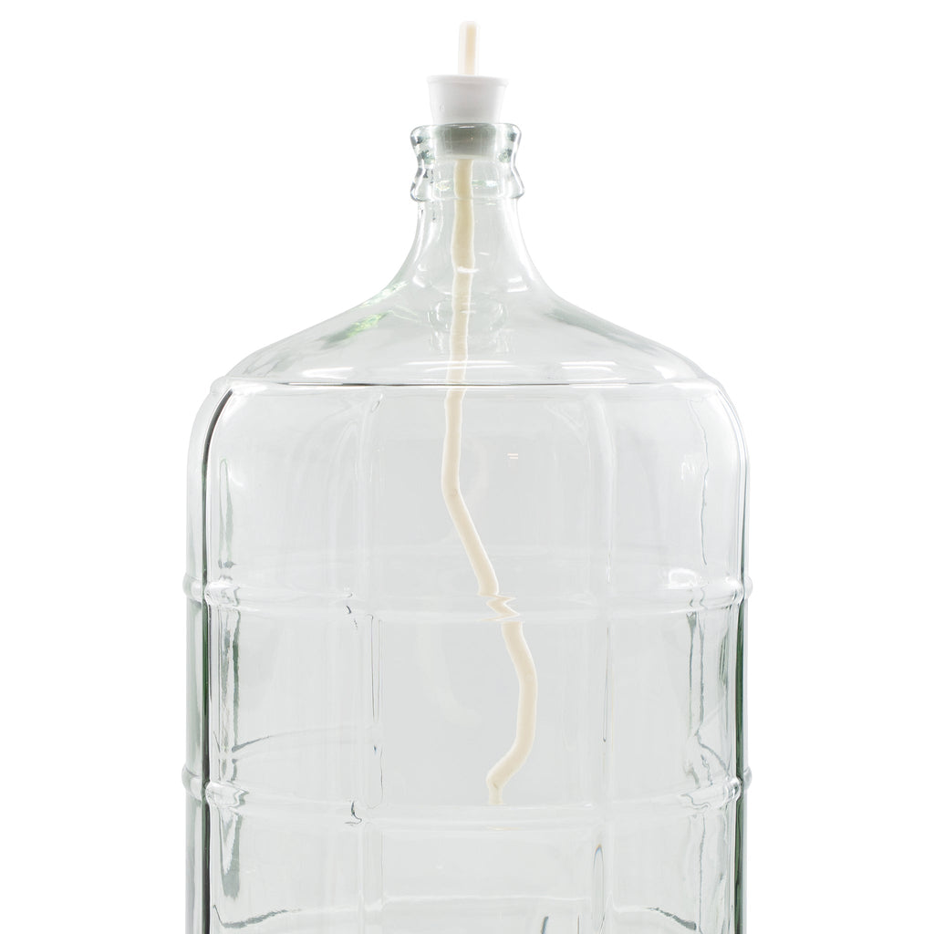 Clear glass carboy fitted with a drilled stopper and wine whip degassing tool, used to remove CO₂ from finished wine during the degassing stage of home wine making.