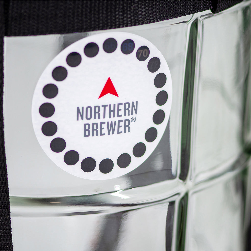 Close-up of the Northern Brewer adhesive temperature strip on a glass carboy, used for monitoring fermentation temperature.