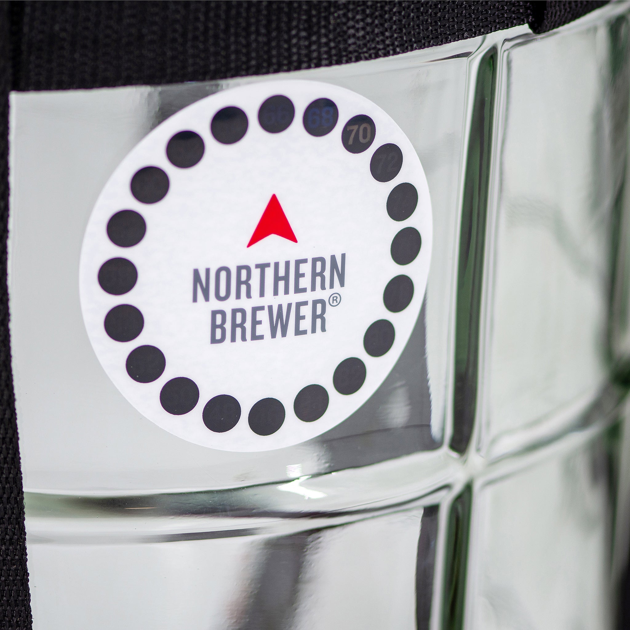 Close-up of the Northern Brewer adhesive temperature strip on a glass carboy, used for monitoring fermentation temperature.