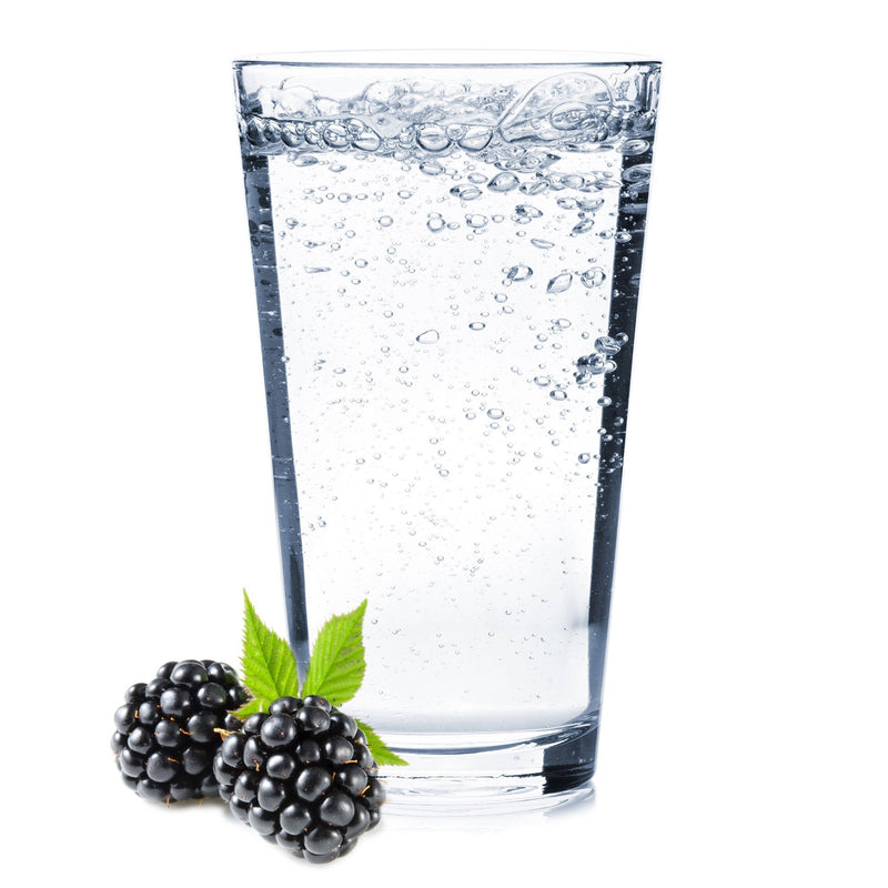 A glass of Blackberry Hard Seltzer with fresh blackberries next to it.