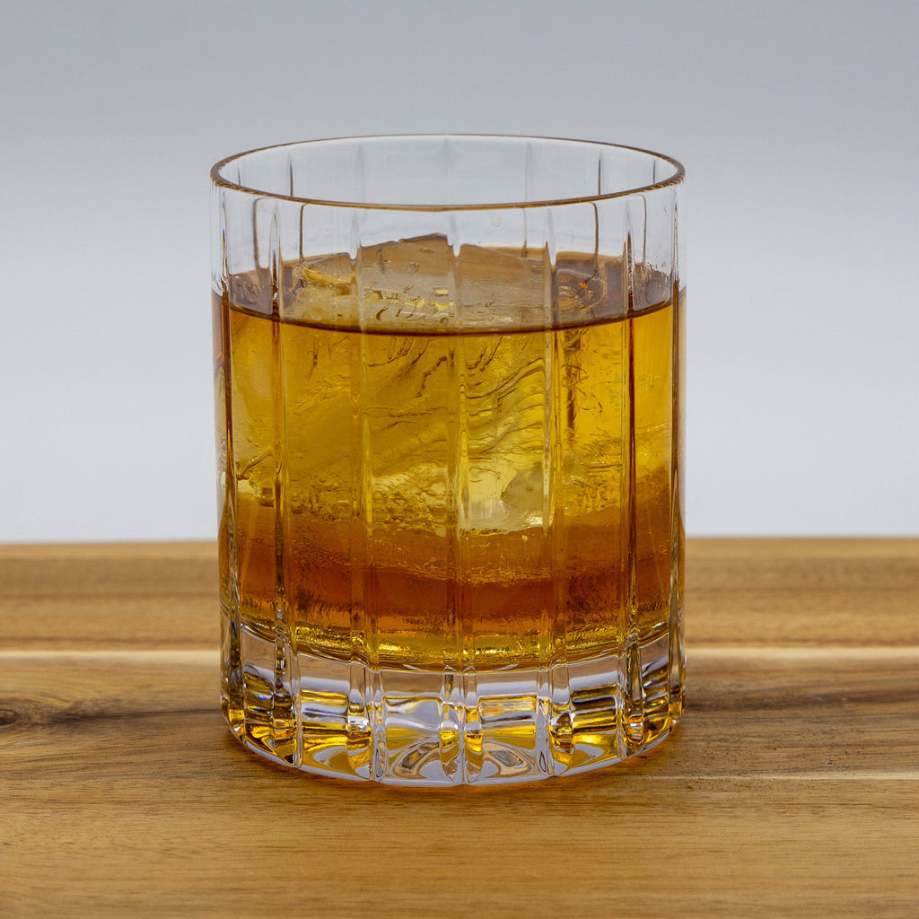 High Rye Bourbon Whiskey in a glass with ice on a wood table.