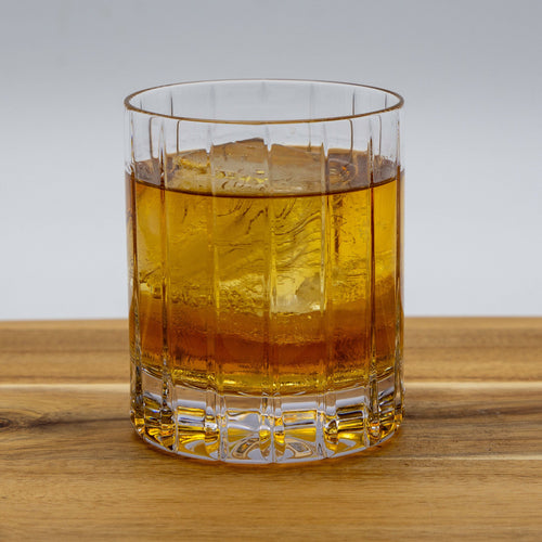 High Rye Bourbon Whiskey in a glass with ice on a wood table.