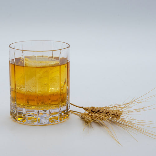 Single malt whiskey in  glass with barely next to it.