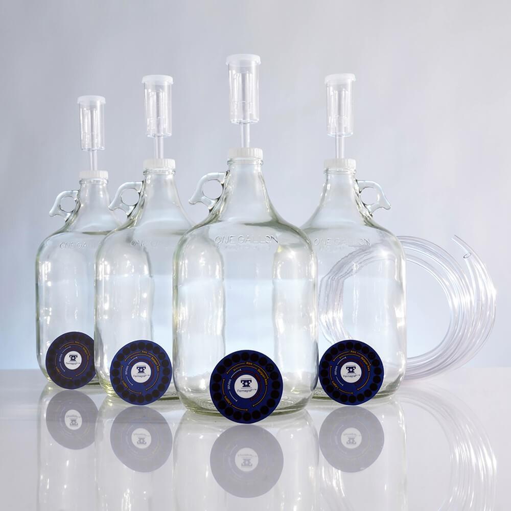 Four one-gallon fermentors, adhesive thermometers, screw caps, lengths of blowoff tubing, and airlocks