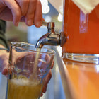 Someone pouring kombucha out of a fermentor using the spigot