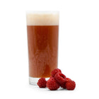 Pile of Raspberries in front of a glass of Fruit Stand Wheat Beer