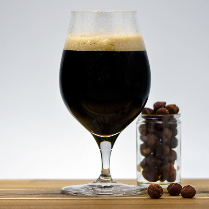Hazelnut Pastry Stout beside a glass of hazelnuts