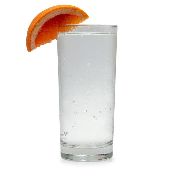 Ruby Grapefruit Hard Seltzer in a glass with a grapefruit wedge