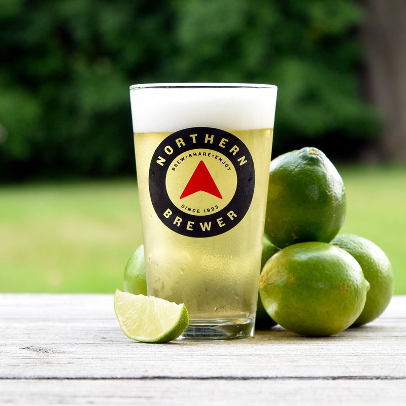 Lime Tree Lager in a Northern Brewer glass with limes around it.